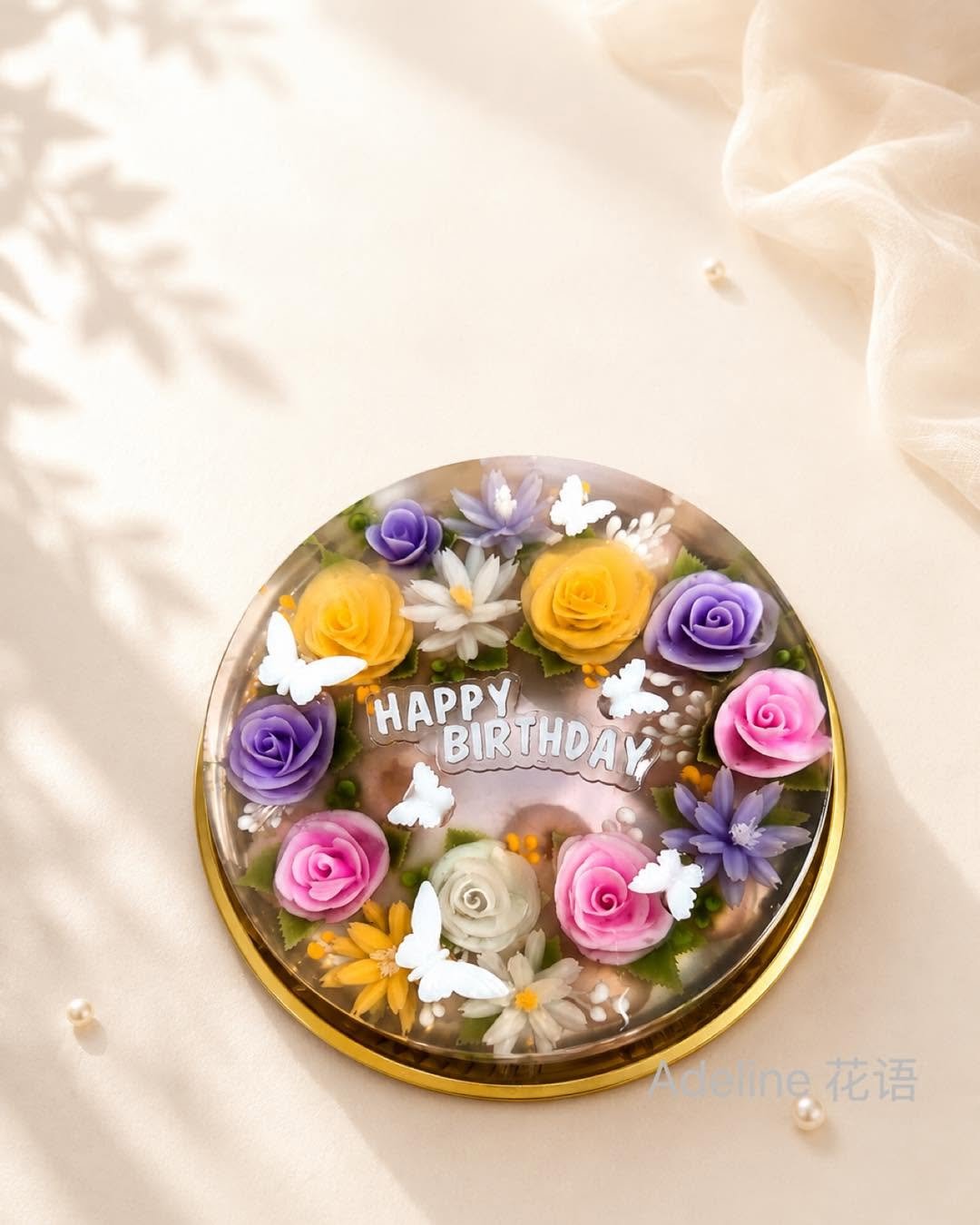 Round jelly cake with a wreath of roses and Happy Birthday lettering